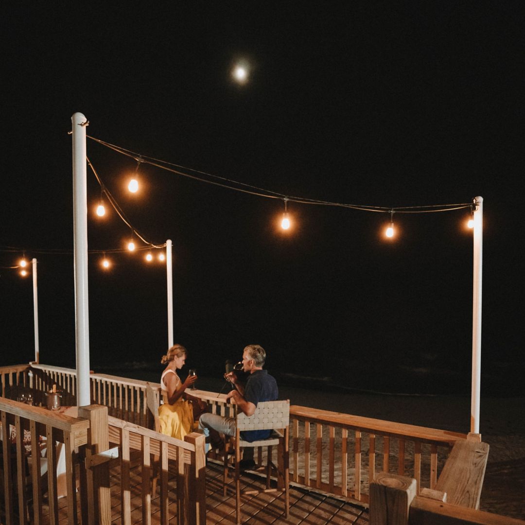 Dinner for two under night sky on beach front terrace